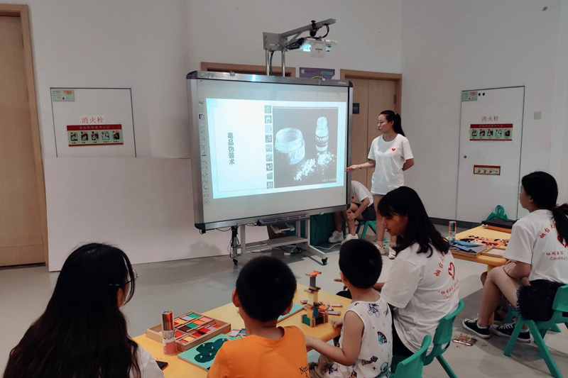 队员利用PPT为莱山区图书馆参加“七彩夏令营”的孩子们讲解毒品的来源和危害。.jpg